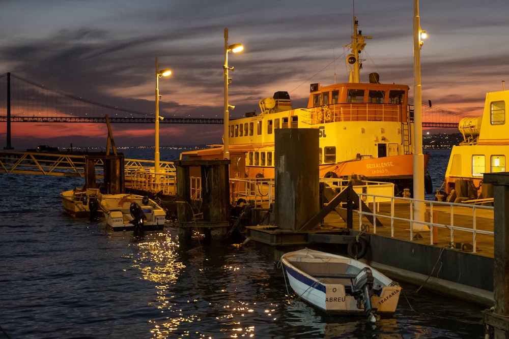 white and blue boat on dock during sunset