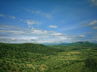 A wide shot of the sprawling 100-acre ranch with rolling hills and open skies.