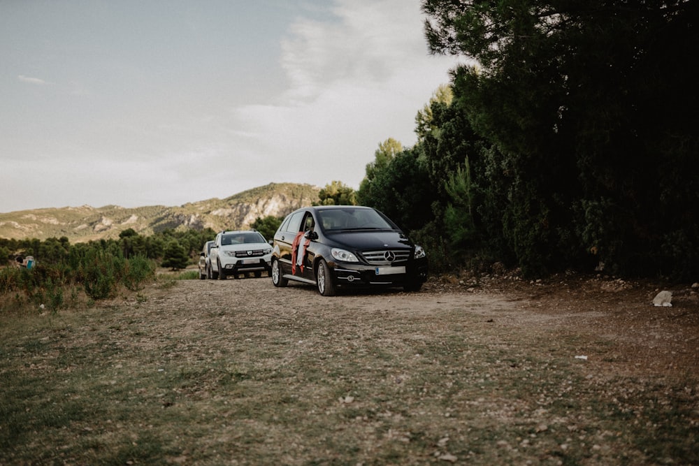 black car on dirt road during daytime