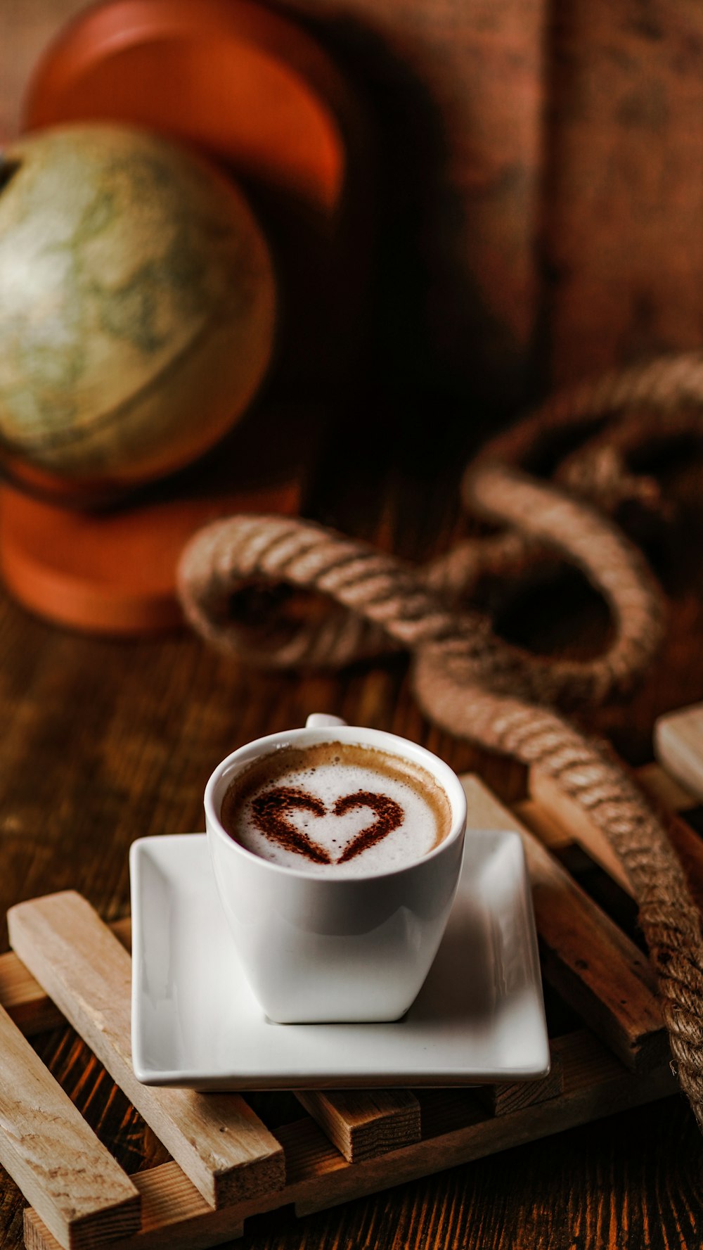 white ceramic mug with coffee on brown wooden table