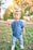 A happy toddler wearing a colorful outfit from Pequenos Encantos, playing in a sunny park.