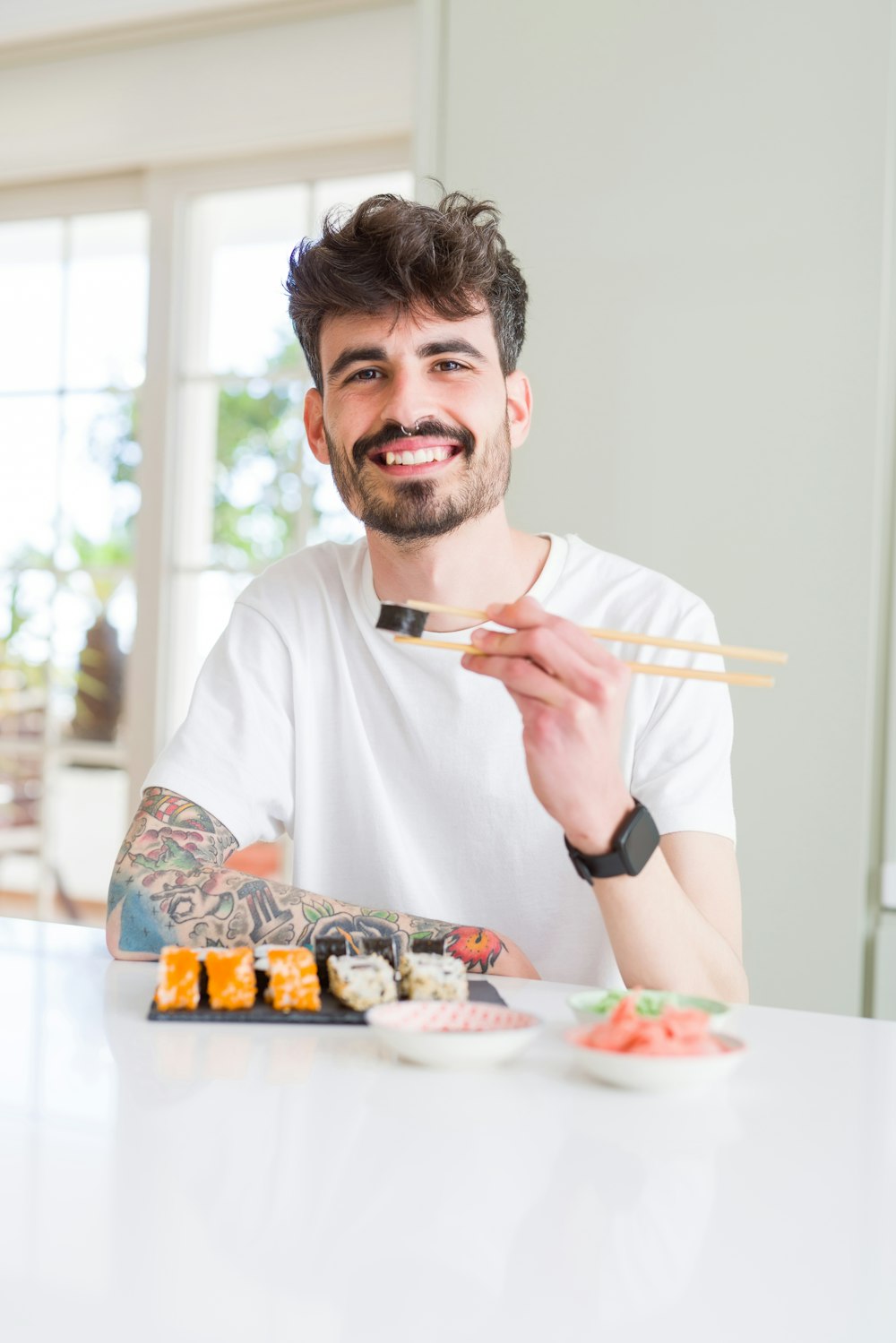 man in white crew neck t-shirt holding white chopsticks