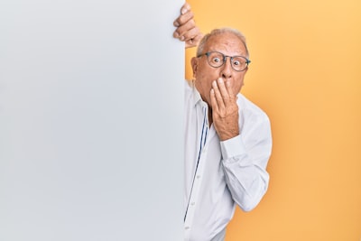 man in white dress shirt wearing black framed eyeglasses expressive teams background