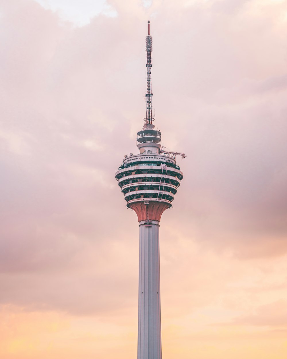 white and black tower under white clouds