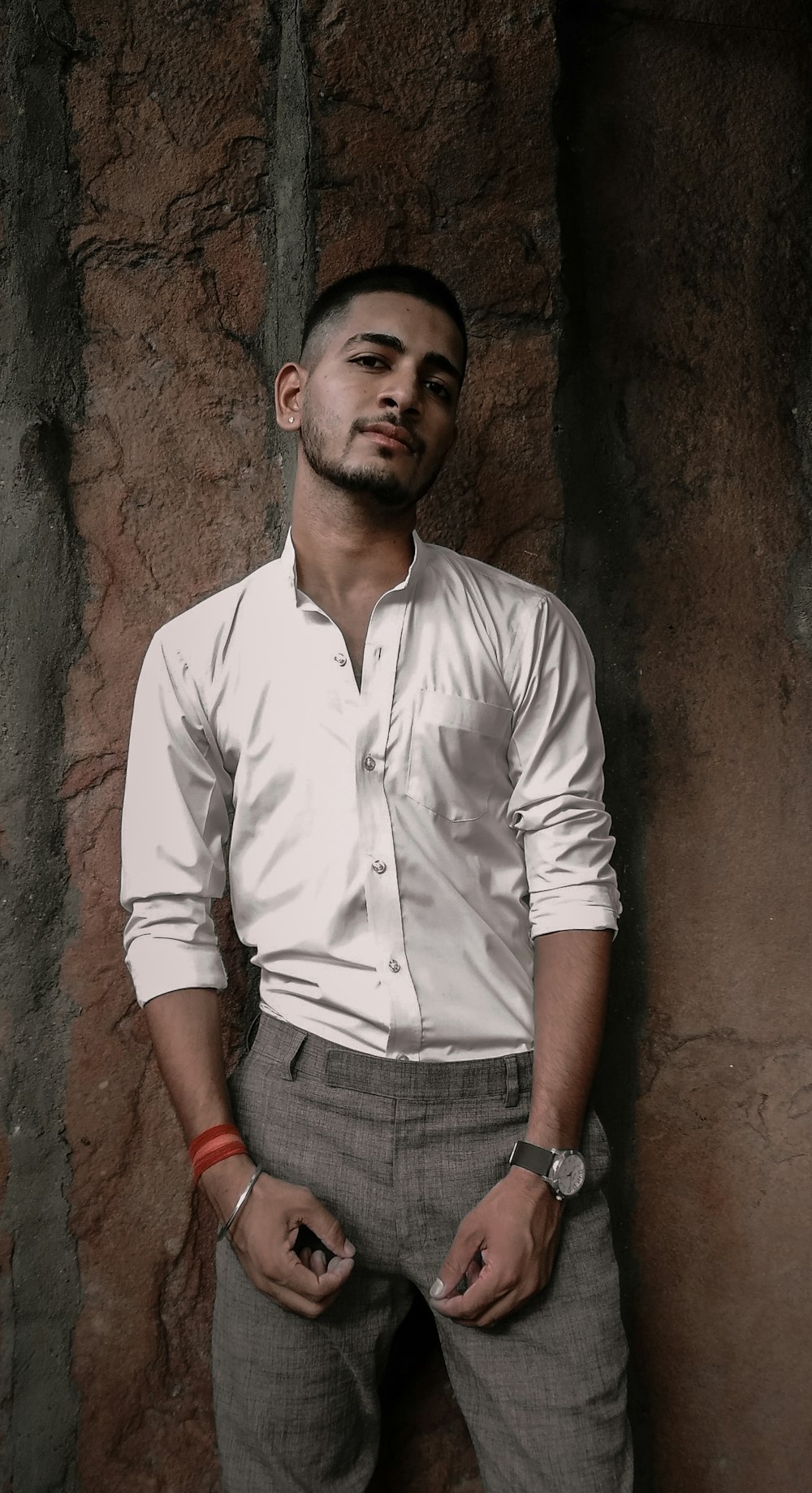 Uomo in camicia bianca e jeans in denim grigio in piedi accanto al muro di  cemento marrone foto – Rajasthan Immagine gratuita su Unsplash