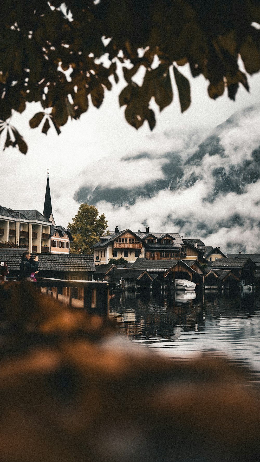 green and brown house near body of water under gray clouds