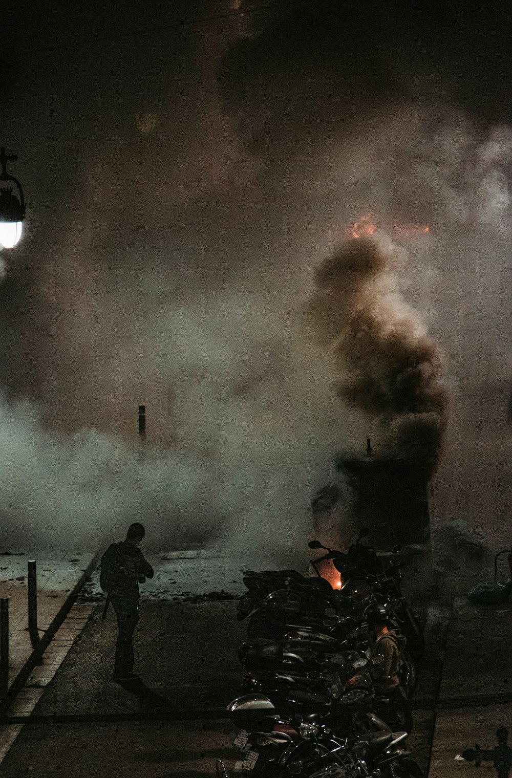 man standing on brown wooden dock near fire