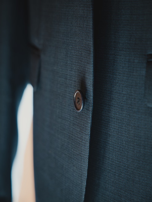 Close-up of a finely detailed three-piece suit fabric with rich textures and deep black color