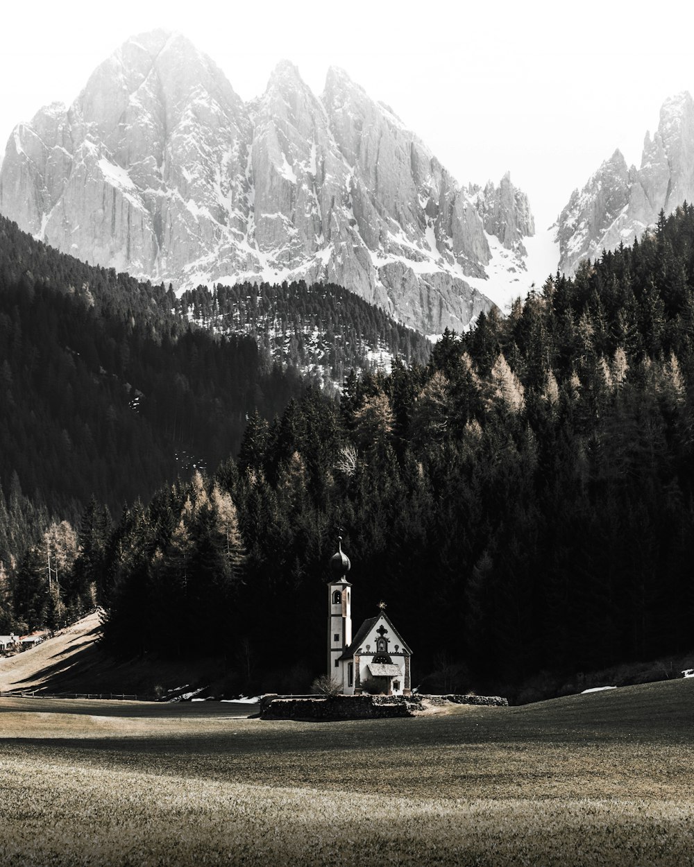 white and brown house near green trees and mountain during daytime