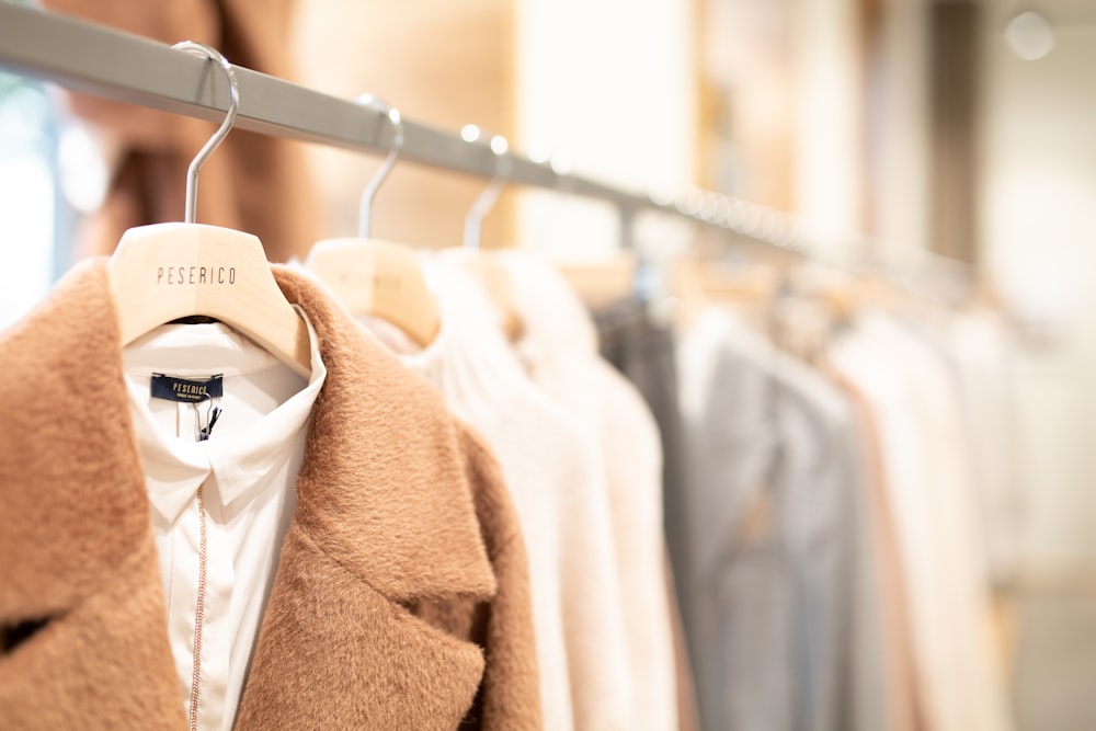 manteau marron accroché sur cintre en plastique blanc