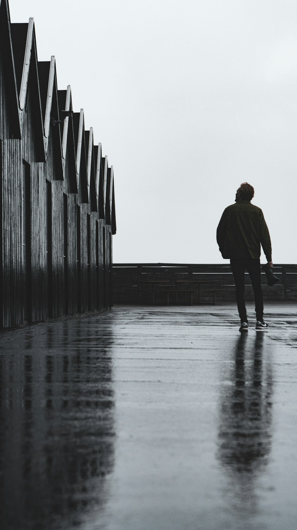 man in black coat walking on gray concrete stairs