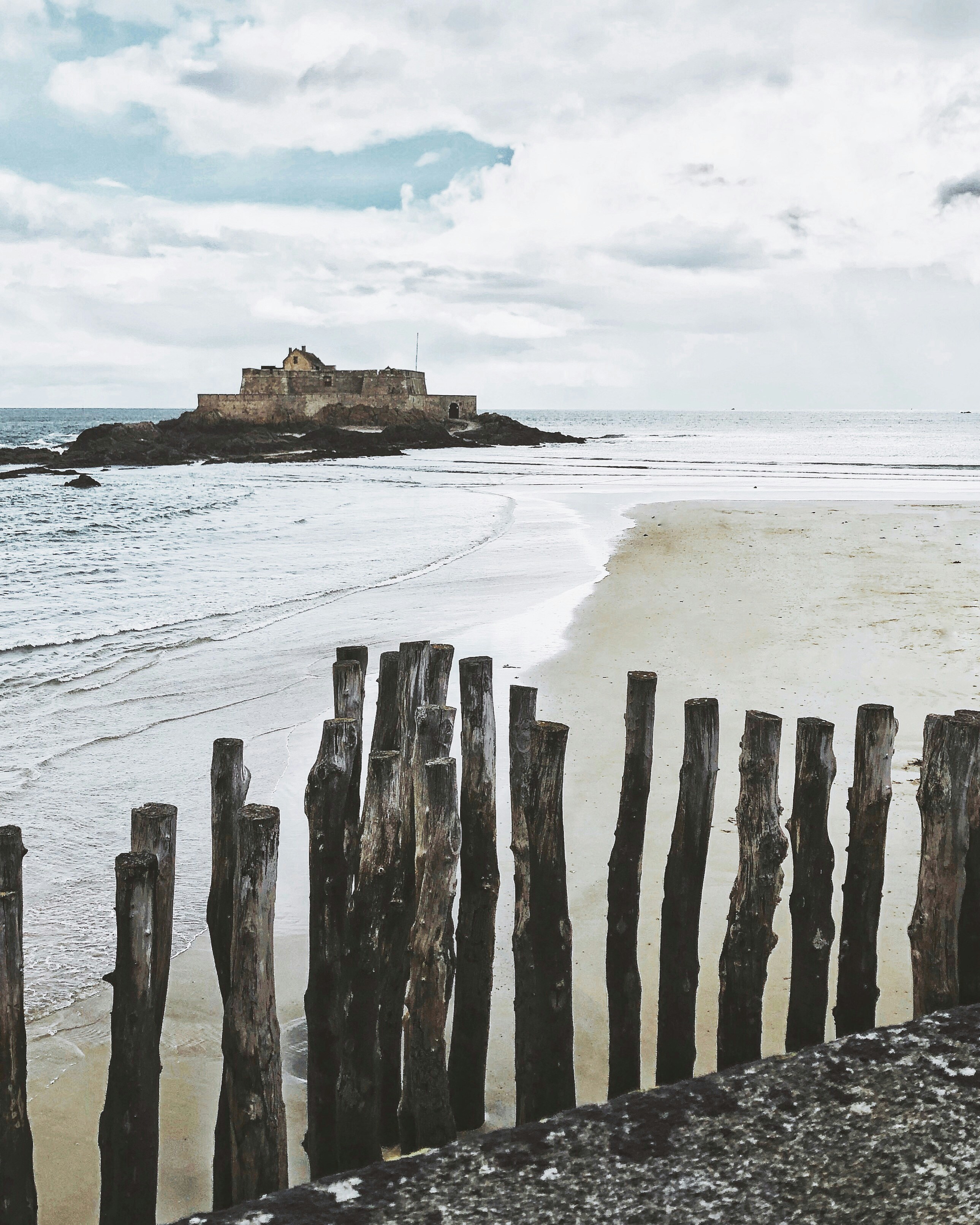 brown wooden posts on beach during daytime