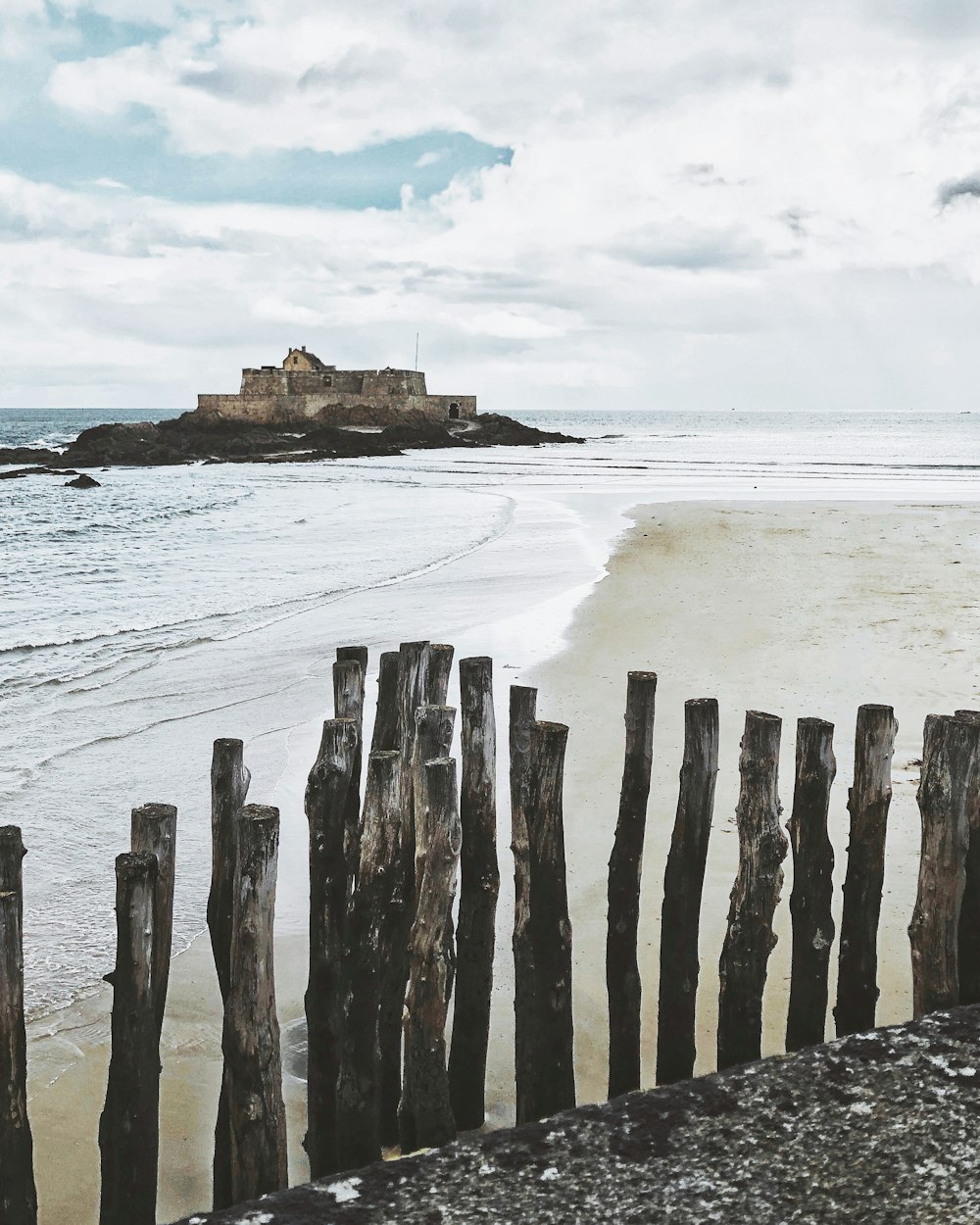 brown wooden posts on beach during daytime