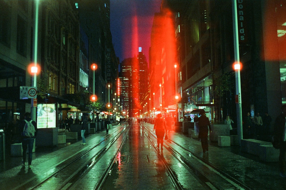 people walking on sidewalk during night time