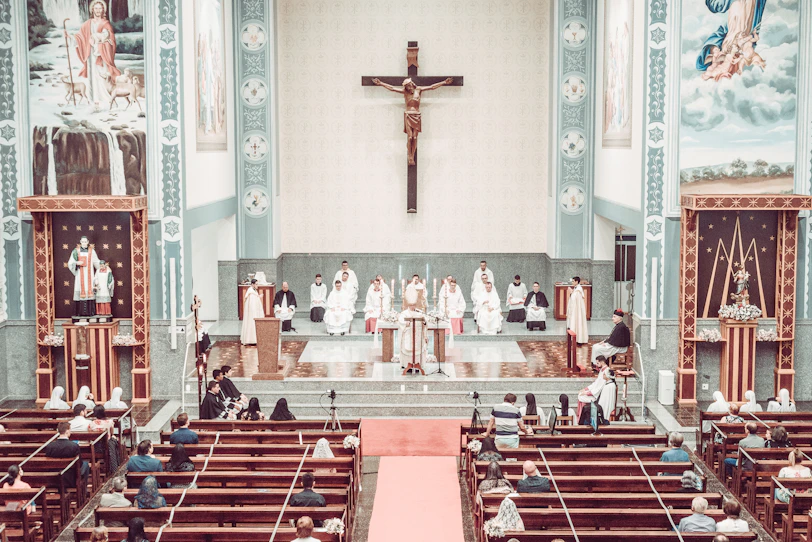 people sitting on red and white chairs inside church
