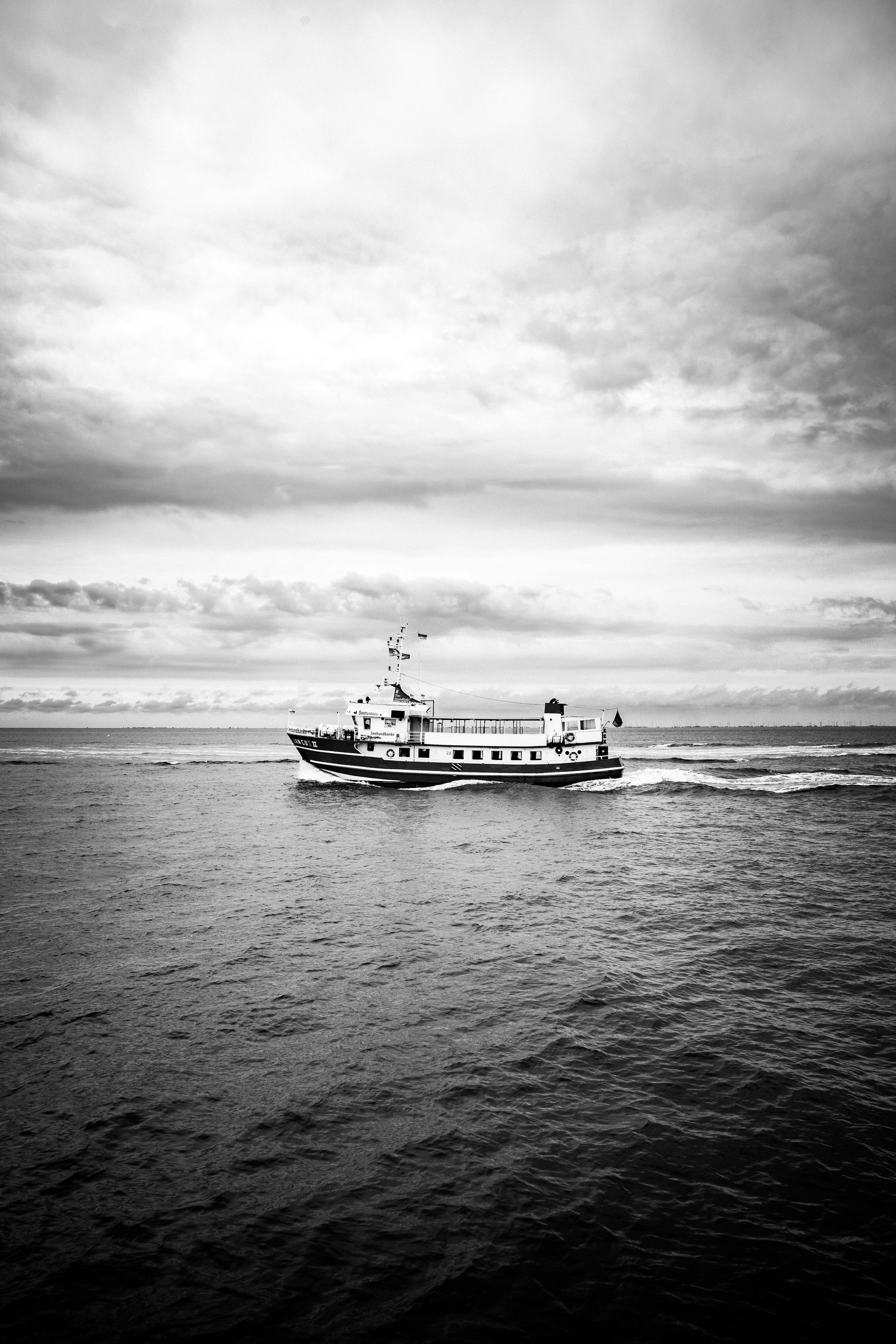 white ship on sea under cloudy sky during daytime