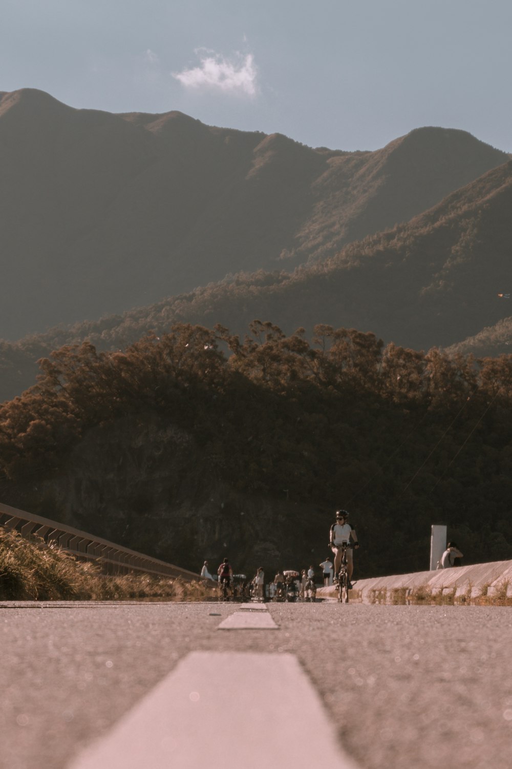 people walking on dirt road near mountain during daytime