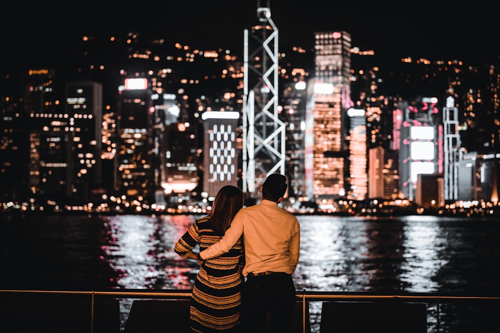 man in yellow shirt and black and white striped pants sitting on dock during night time