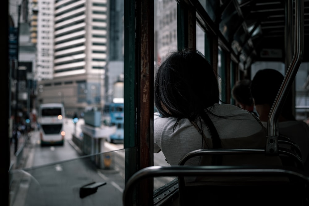 woman in white shirt sitting on train