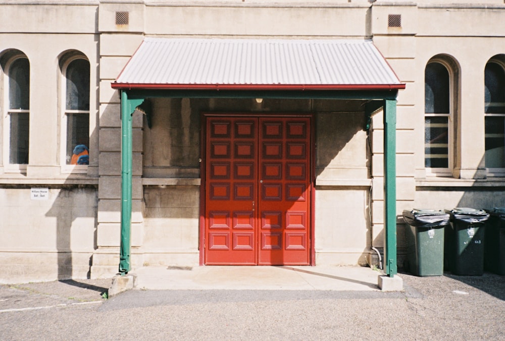 red wooden door on green concrete building