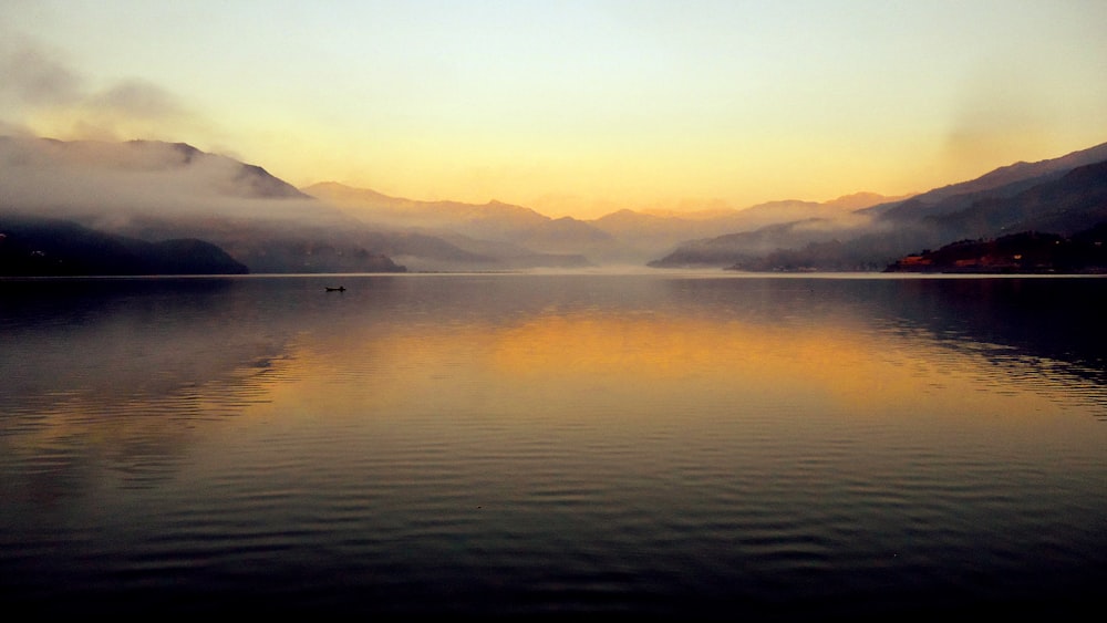 body of water near mountain during daytime