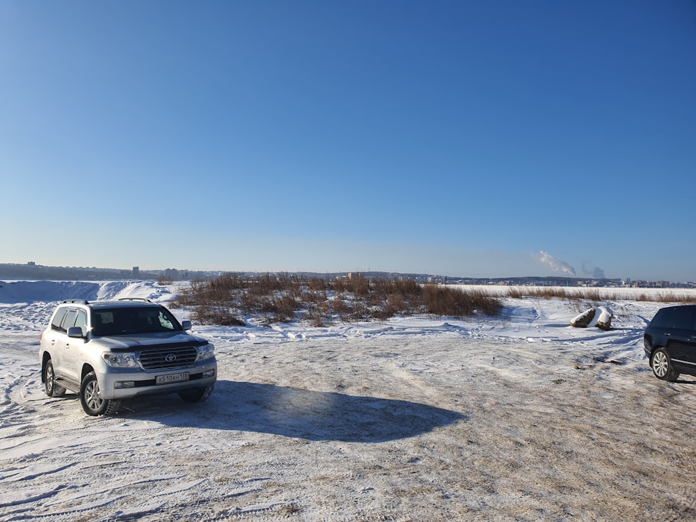 two vehicles parked in the snow on a sunny day