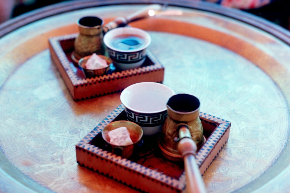 two cups of coffee on a tray on a table