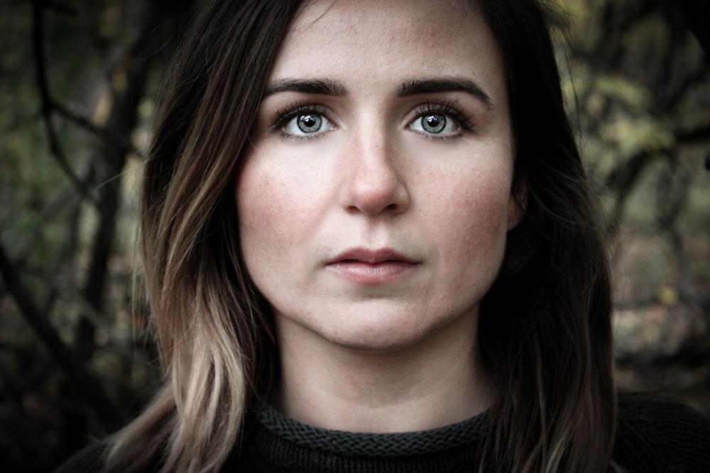 a close up of a person with a tree in the background