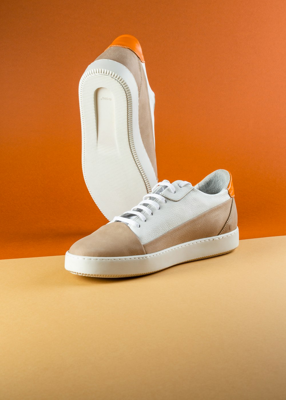 une paire de chaussures blanches et marron sur une table