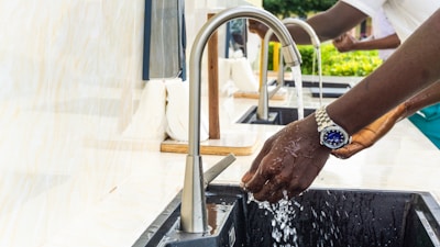 Close-up of hands washing dishes with sparkling clean results in a modern kitchen.
