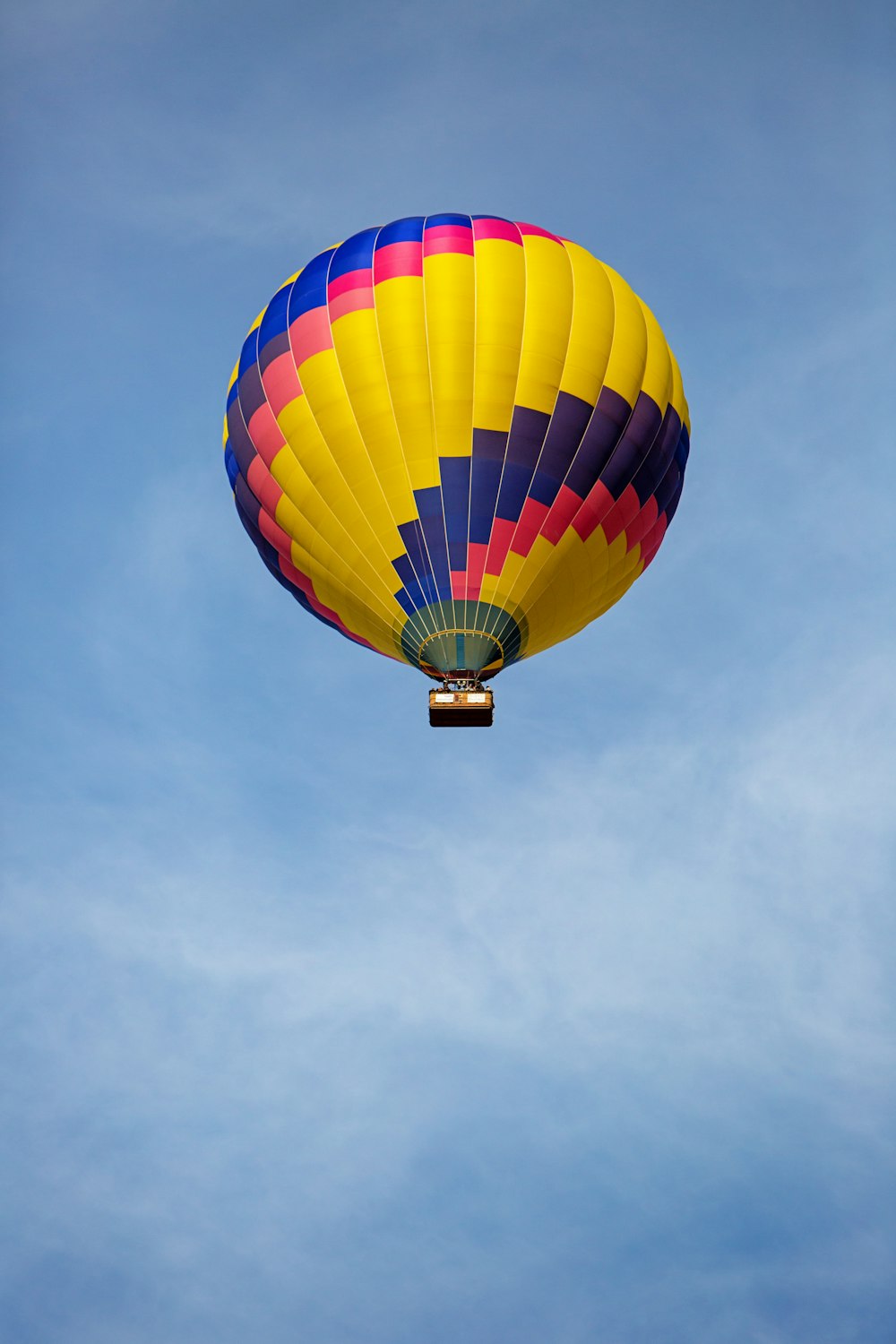 a colorful hot air balloon flying through a blue sky