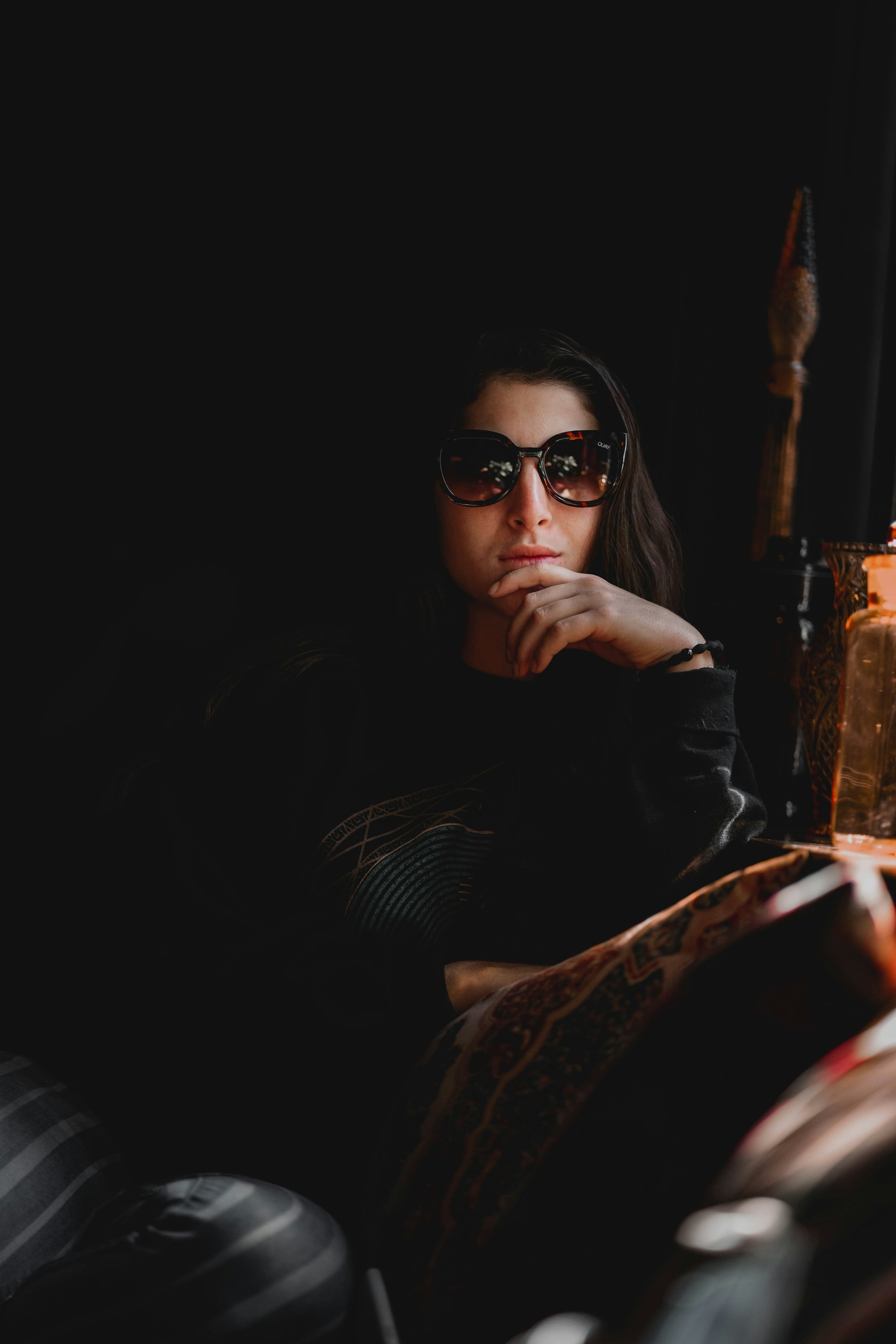 A thoughtful political analyst reviewing notes in a cozy, dimly lit studio featuring the signature dark bluish-purple and yellow color scheme.