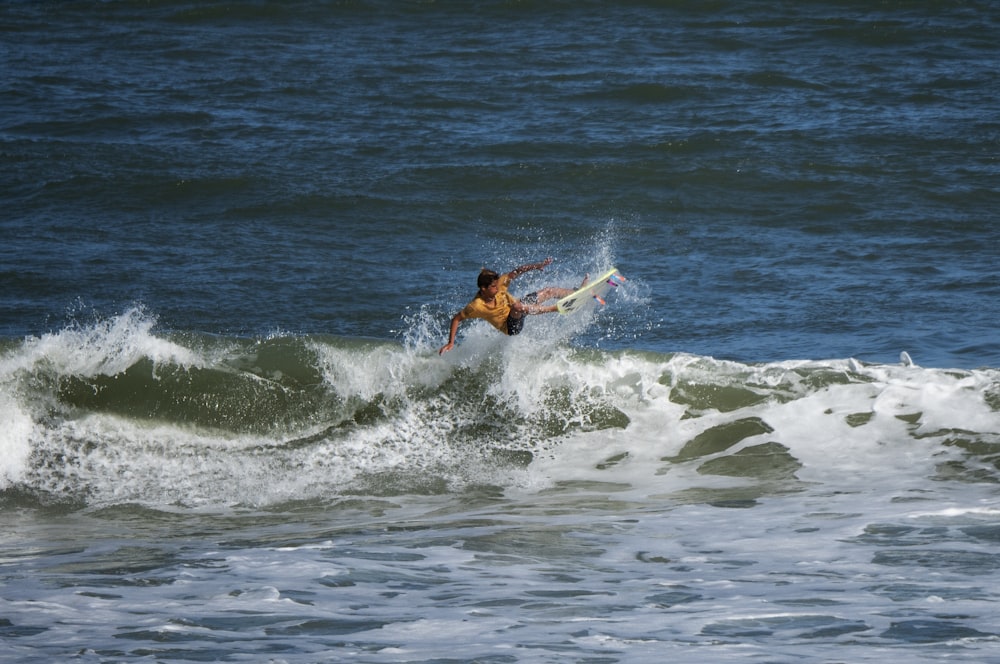 man surfing on sea waves during daytime