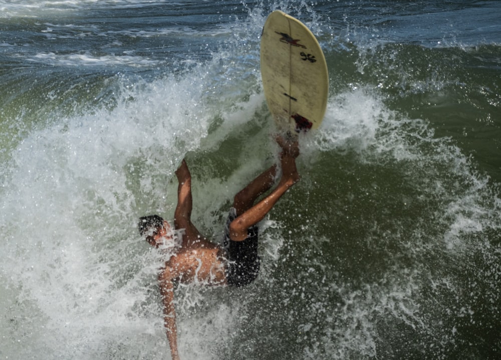 2 person surfing on sea waves during daytime