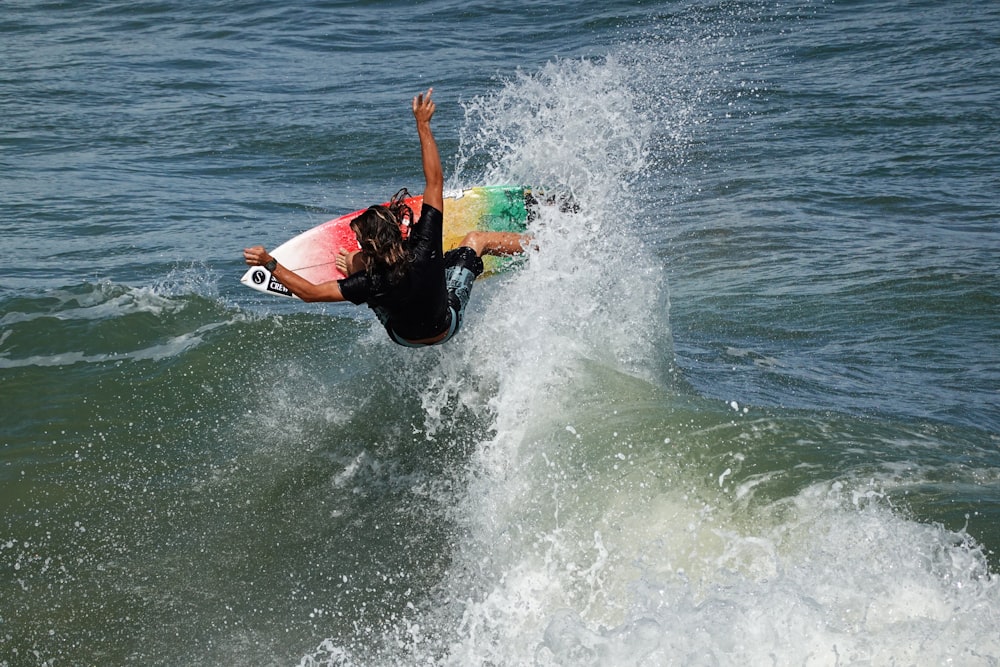 man in black wetsuit surfing on sea waves during daytime