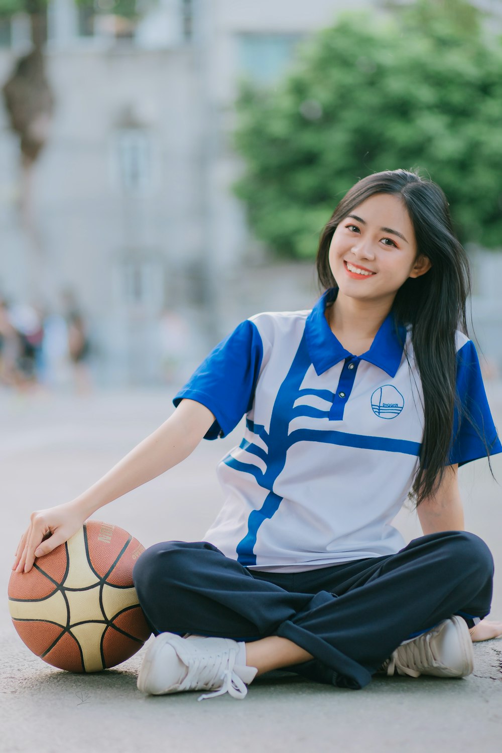 woman in blue and white adidas soccer jersey shirt and black skirt sitting on brown wooden