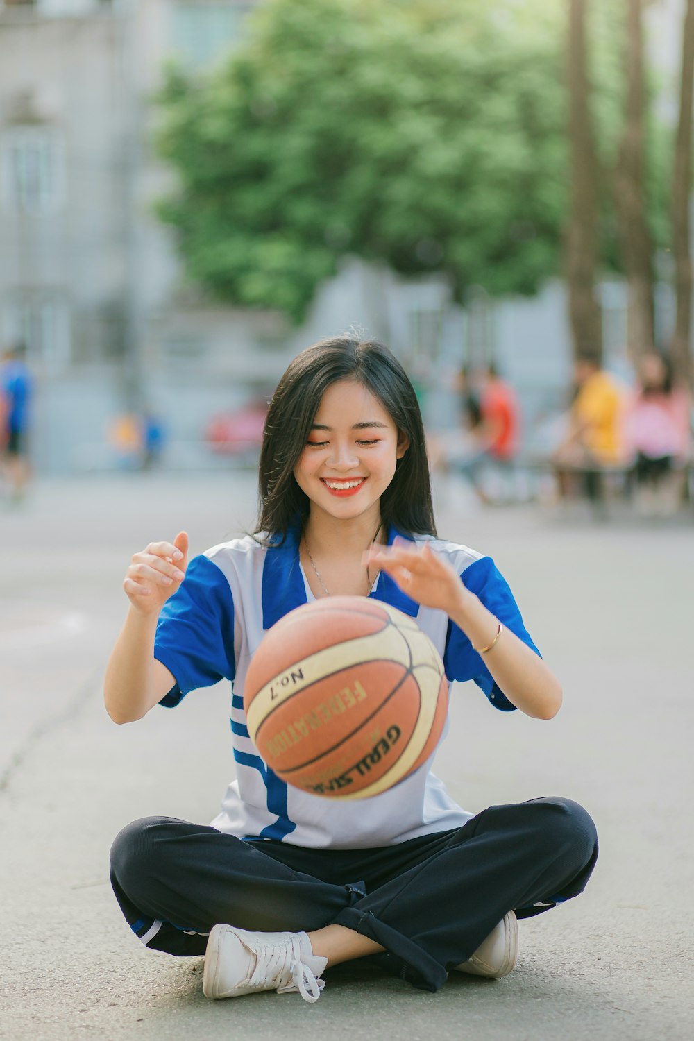 Frau im weißen Hemd hält Basketball