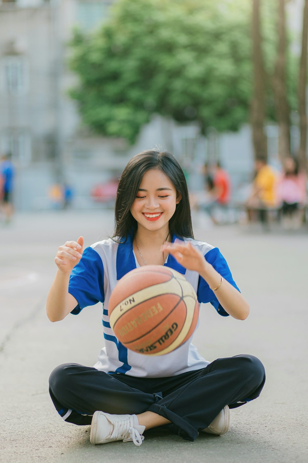 woman in white shirt holding basketball