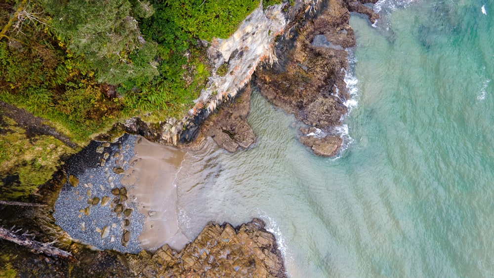 Vista aérea de la montaña verde y marrón al lado del cuerpo de agua durante el día