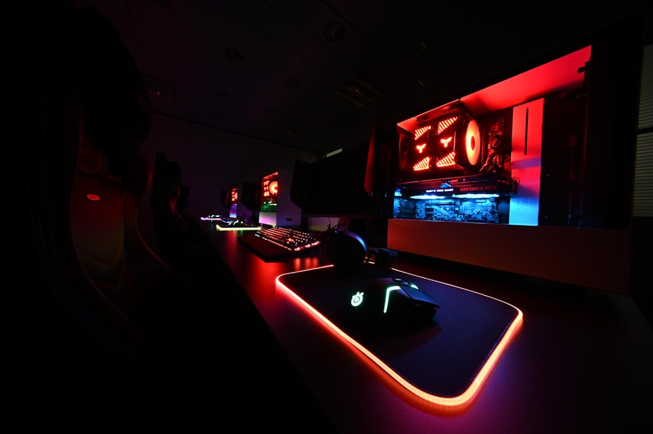 A sleek gaming setup featuring a glowing mechanical keyboard, a high-precision mouse, and immersive headphones with vibrant RGB lighting.