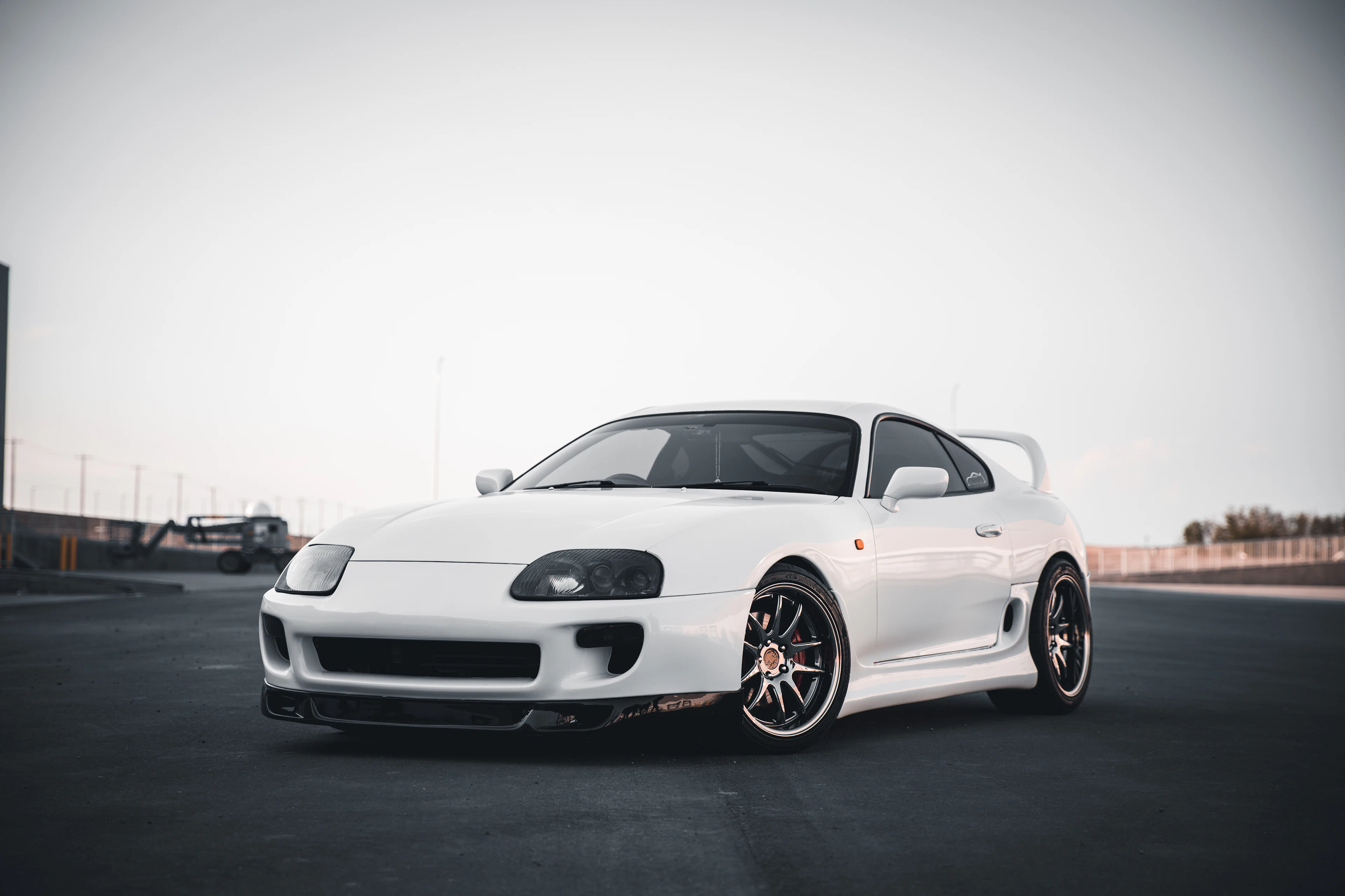 White Toyota Supra Mk4 with a rear wing on a track