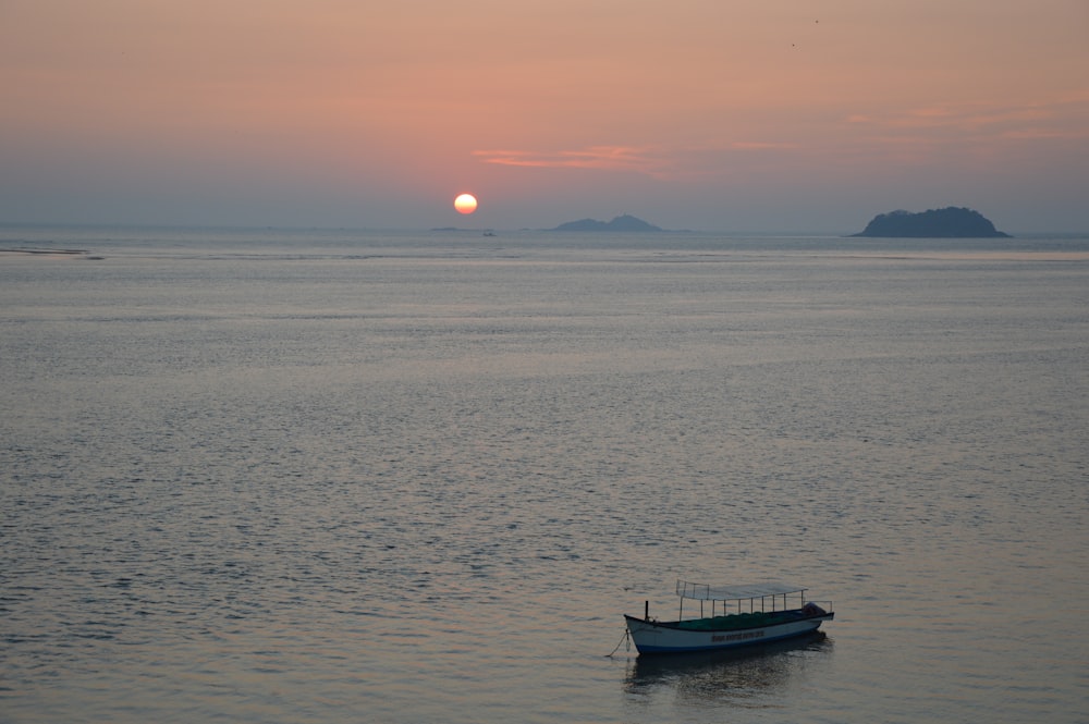 silhouette of boat on sea during sunset