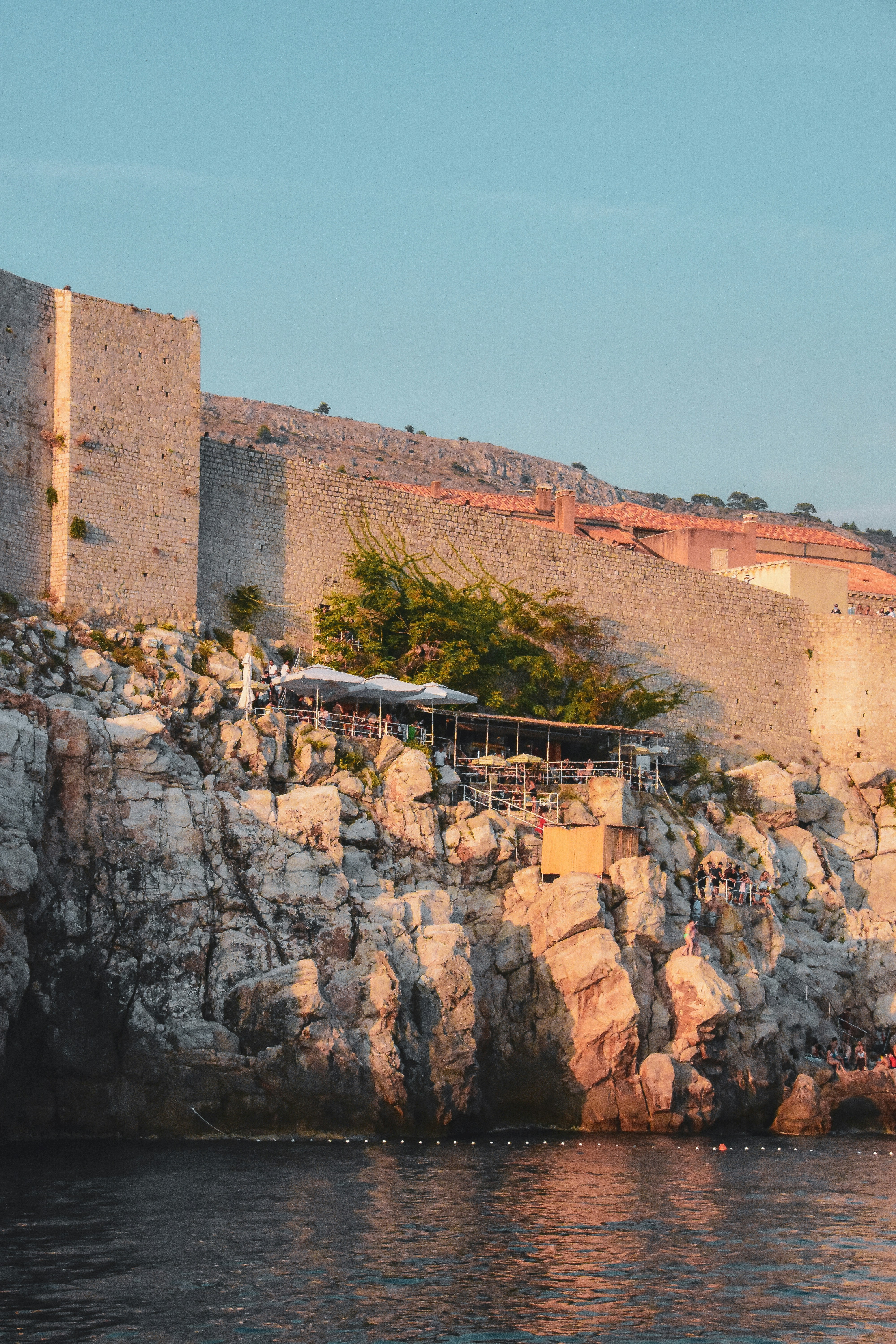 people walking on brown rock formation during daytime