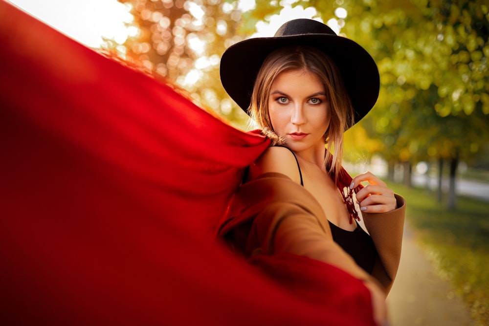 woman in red long sleeve shirt wearing black hat