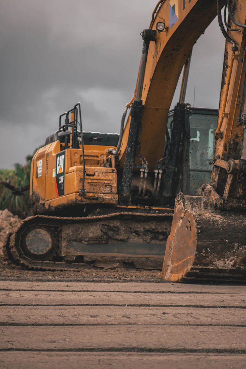 Tracked excavator with mud on the tracks working on site