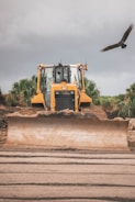 yellow and black heavy equipment on brown sand during daytime