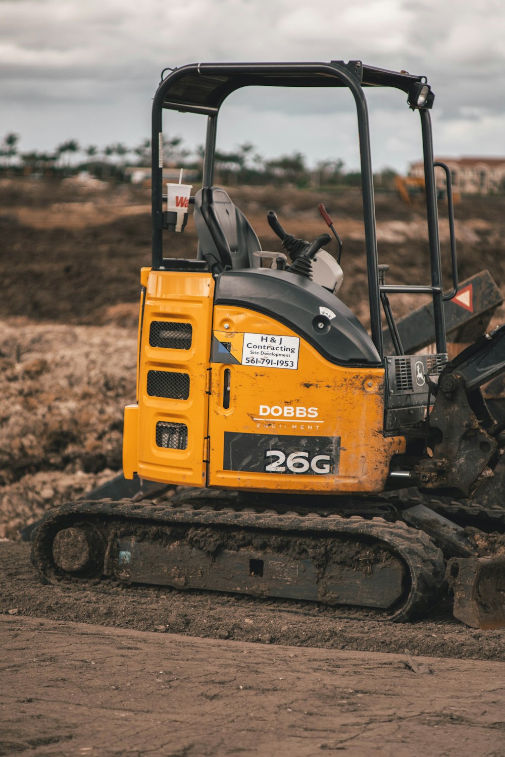 Ein gelber Bulldozer ist im Dreck geparkt