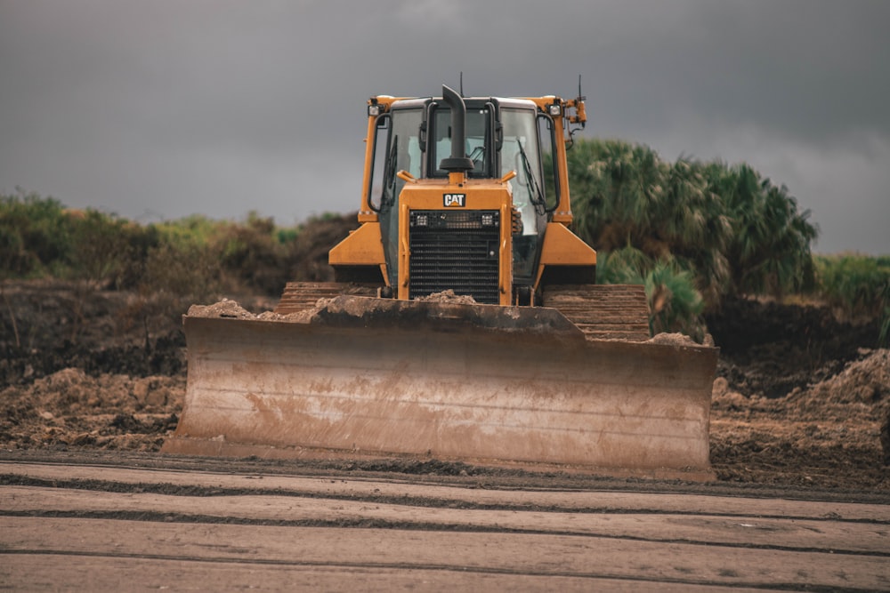 equipamento pesado laranja e preto na areia marrom