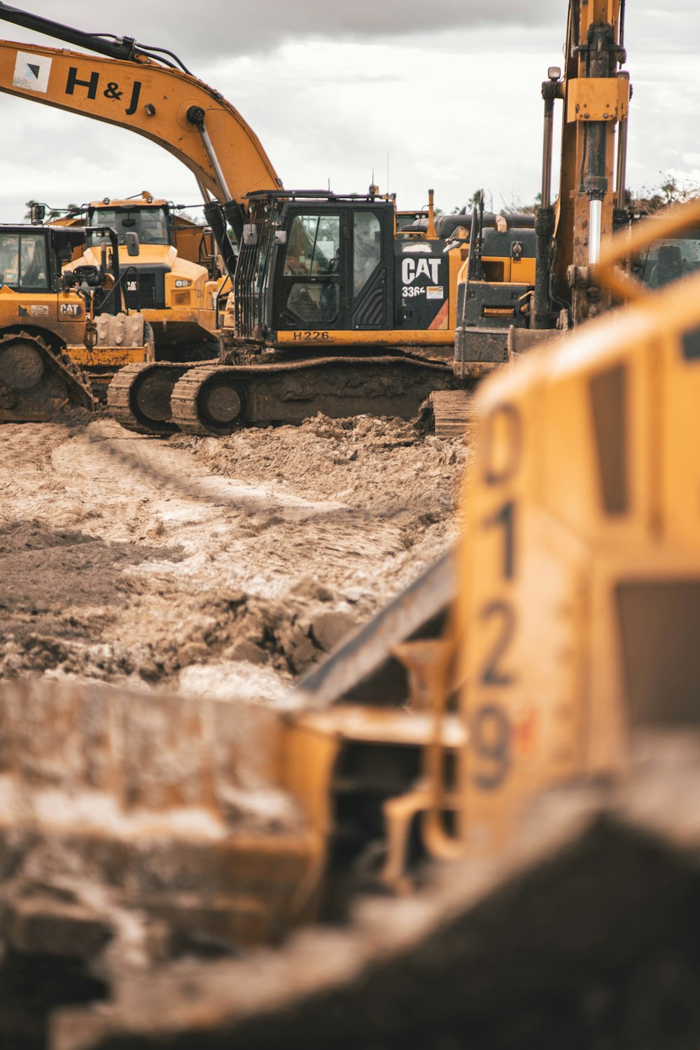 yellow and black excavator on brown soil