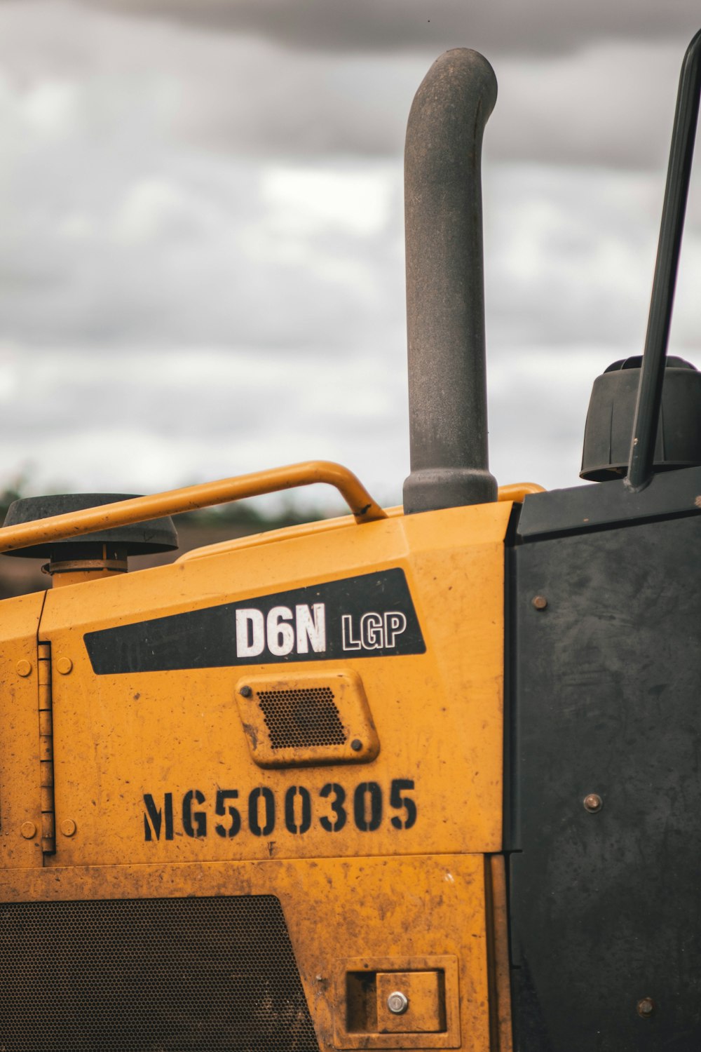 the front of a yellow bulldozer parked on the side of a road